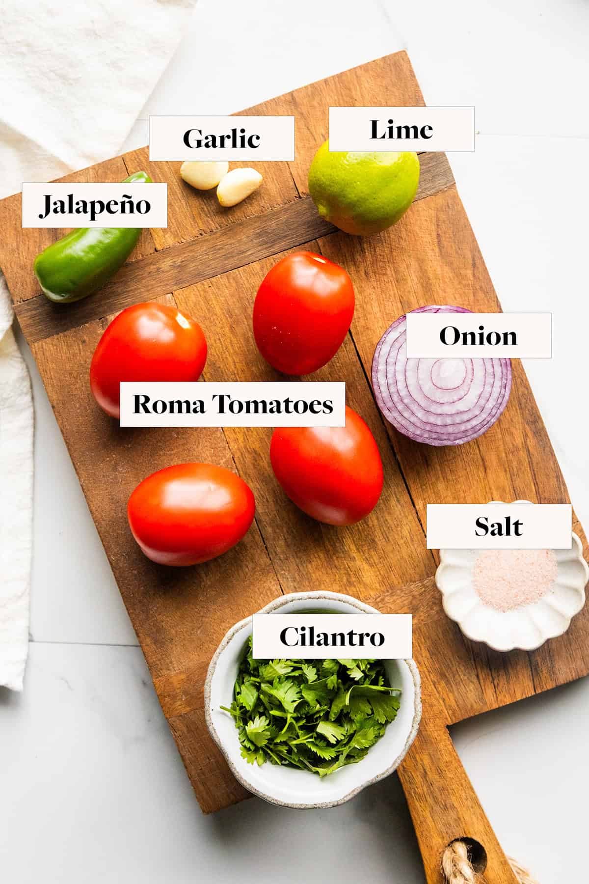 Labeled ingredients for pico de gallo laid out on a table.