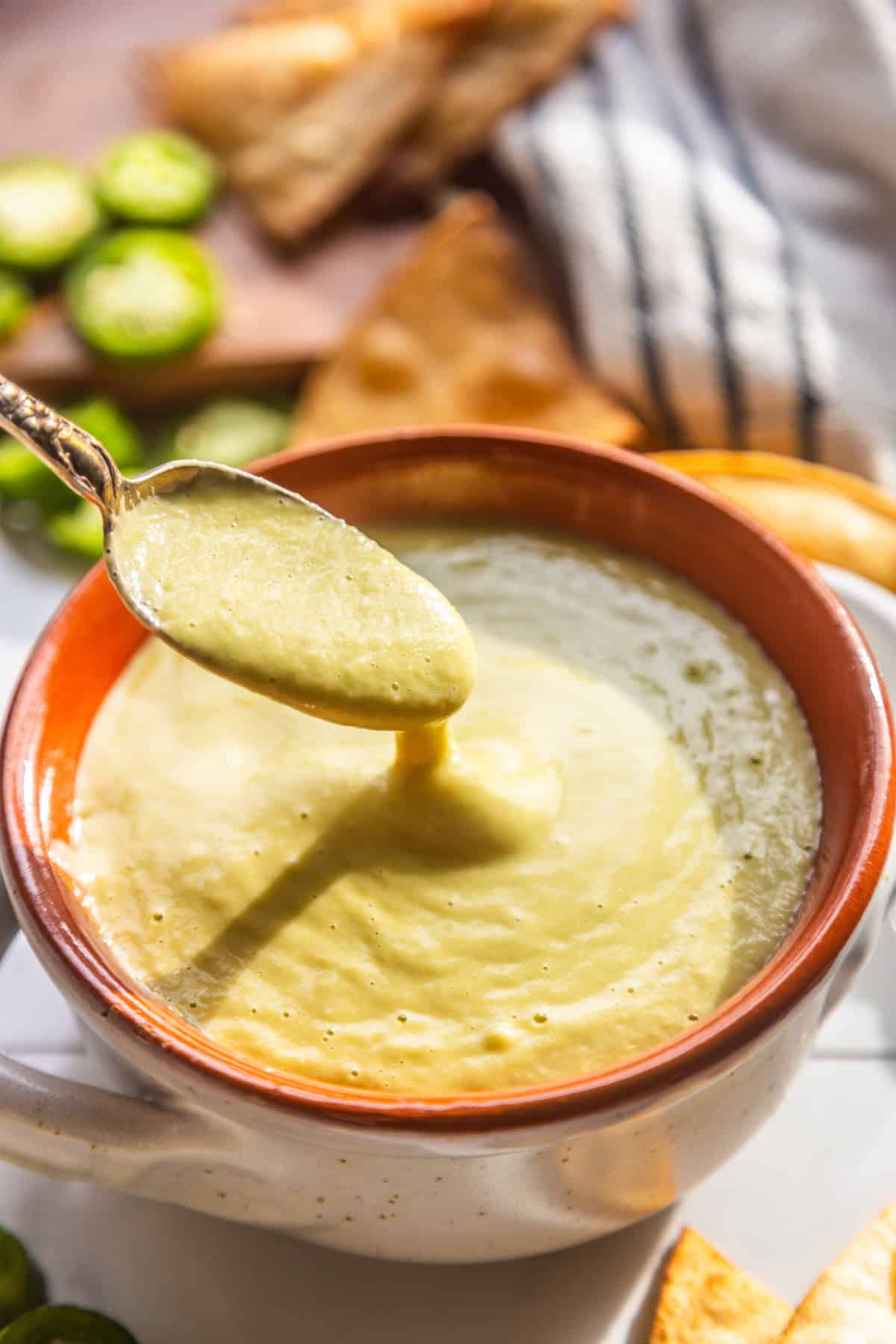 A spoon dipping into creamy jalapeno sauce.