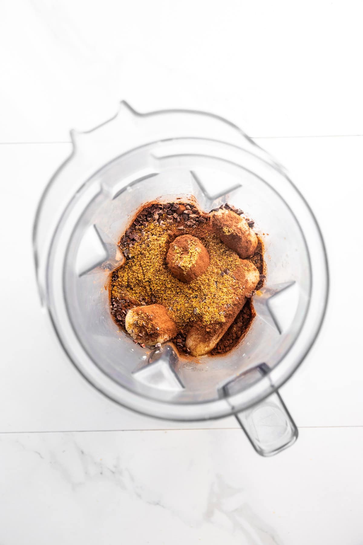 Ingredients for banana cocoa peanut butter smoothie in a blender.