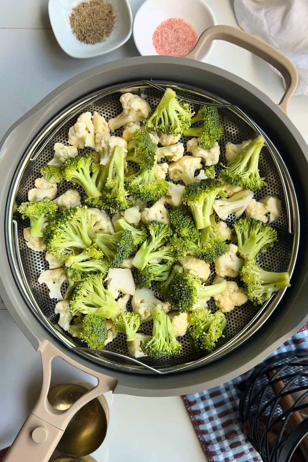 Broccoli and cauliflower sautéing in a pan.