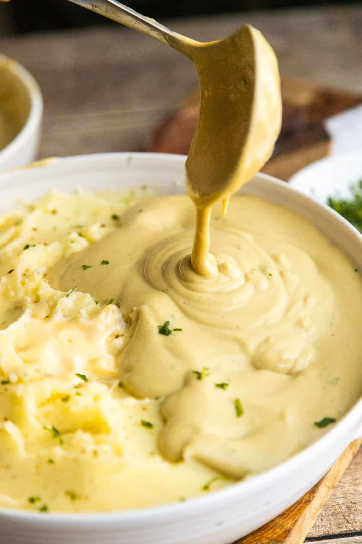 Cashew gravy pouring over mashed potatoes.