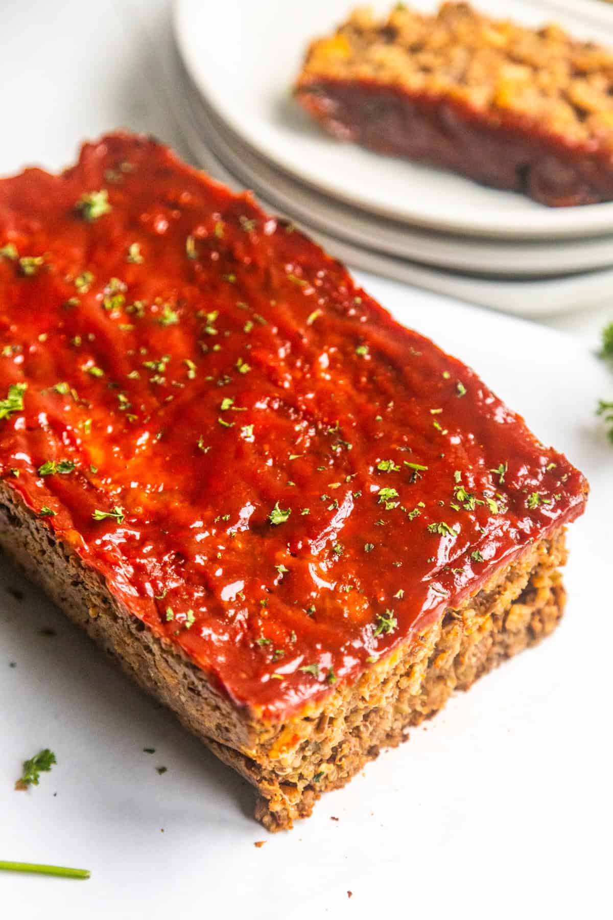 A sliced loaf of vegan meatloaf with lentils and maple sriracha glaze.