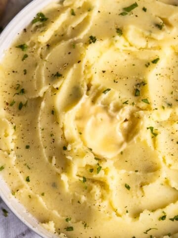 Creamy vegan mashed potatoes in a white bowl.