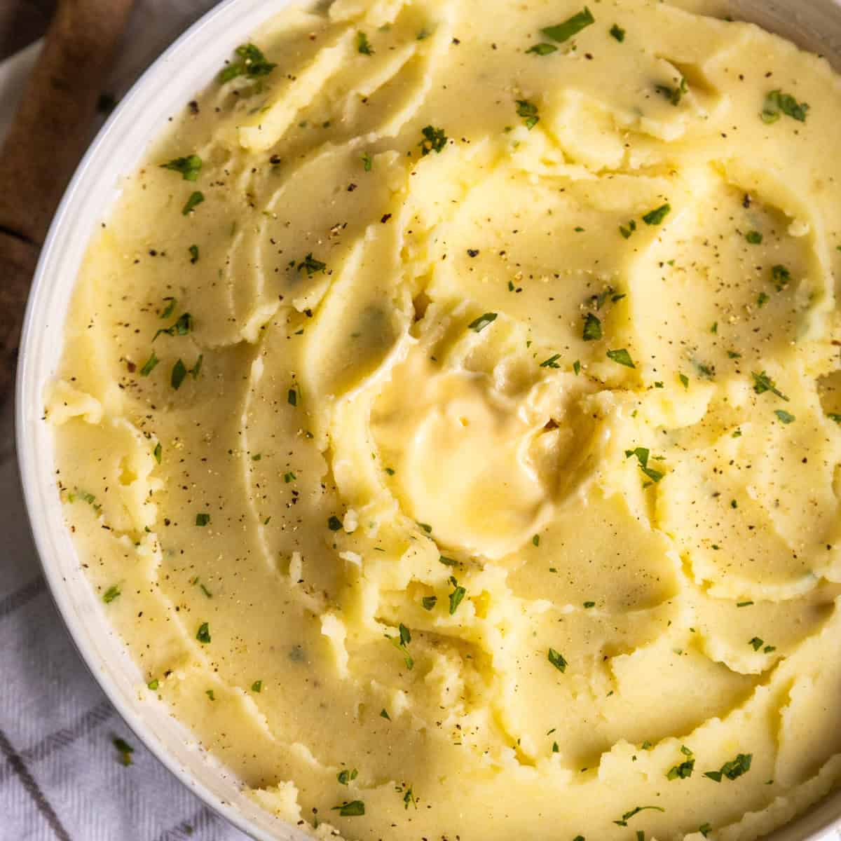 Creamy vegan mashed potatoes in a white bowl.