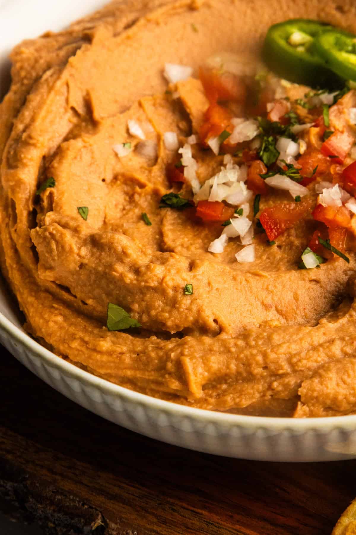 Close up of creamy vegan bean dip in a bowl, highlighting the creamy texture.