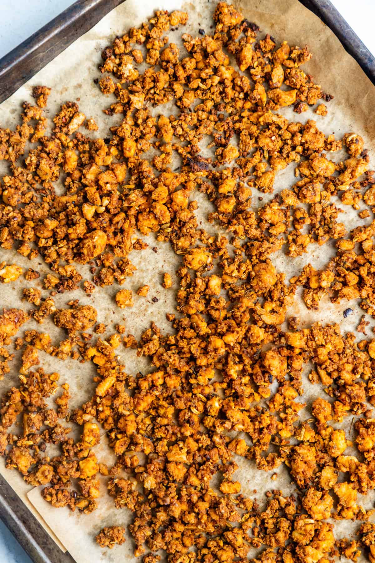 Baked Vegan Italian Sausage Crumbles on a cookie sheet.