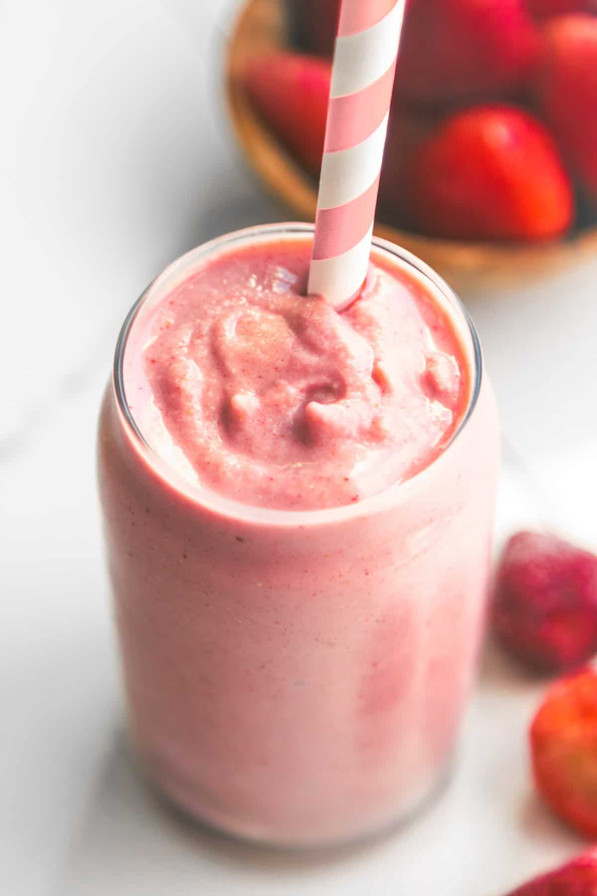 Dairy free strawberry banana smoothie without yogurt in a cup with a pink straw.
