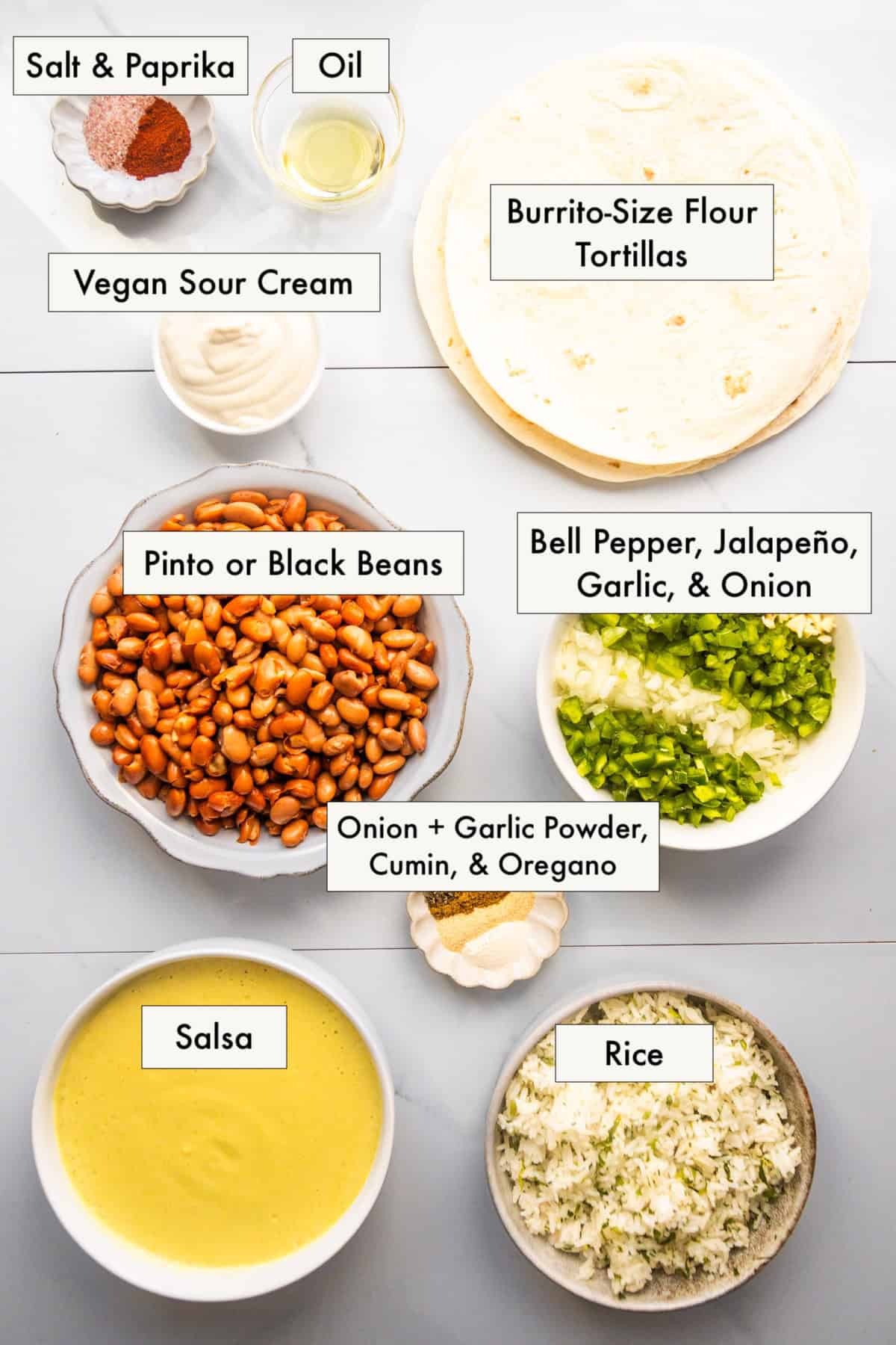All ingredients for smothered beans and rice wet burritos in labeled bowls on a counter.