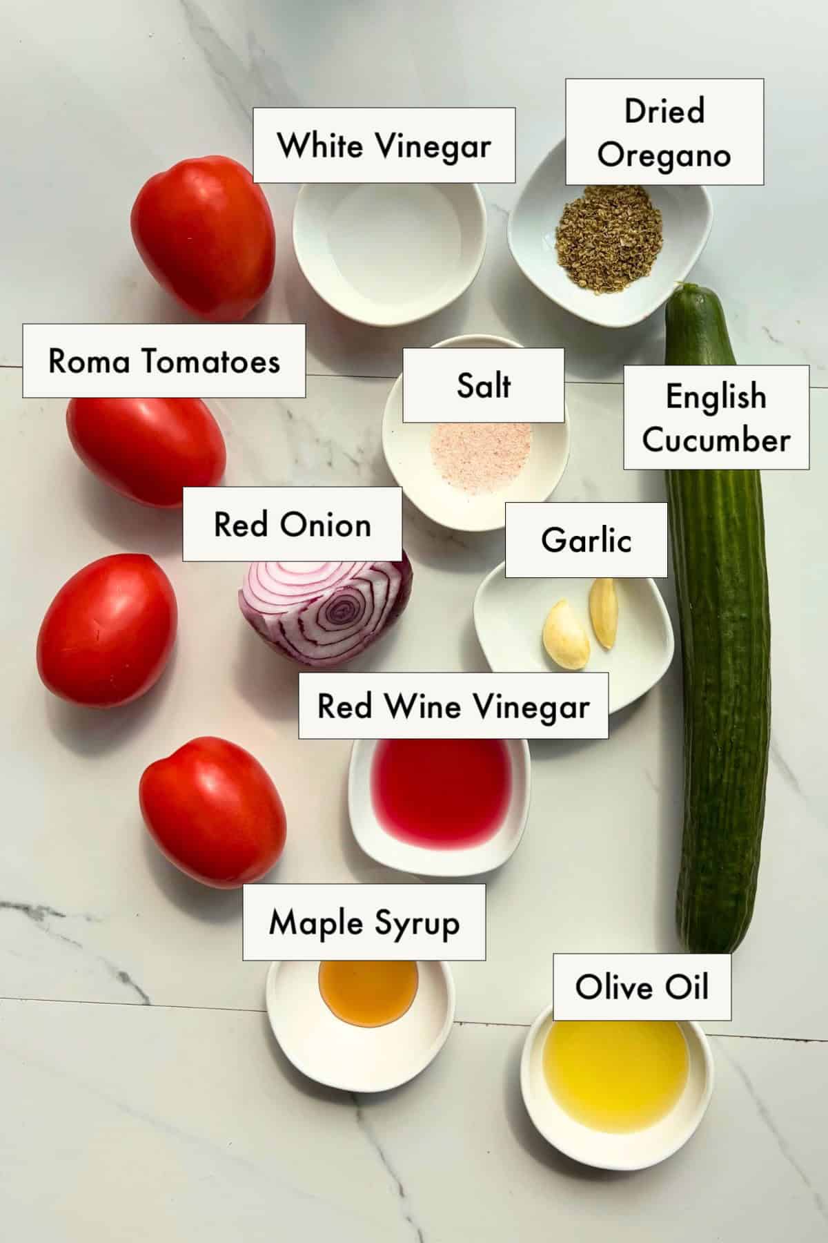 Ingredients for cucumber tomato and onion salad on a counter.