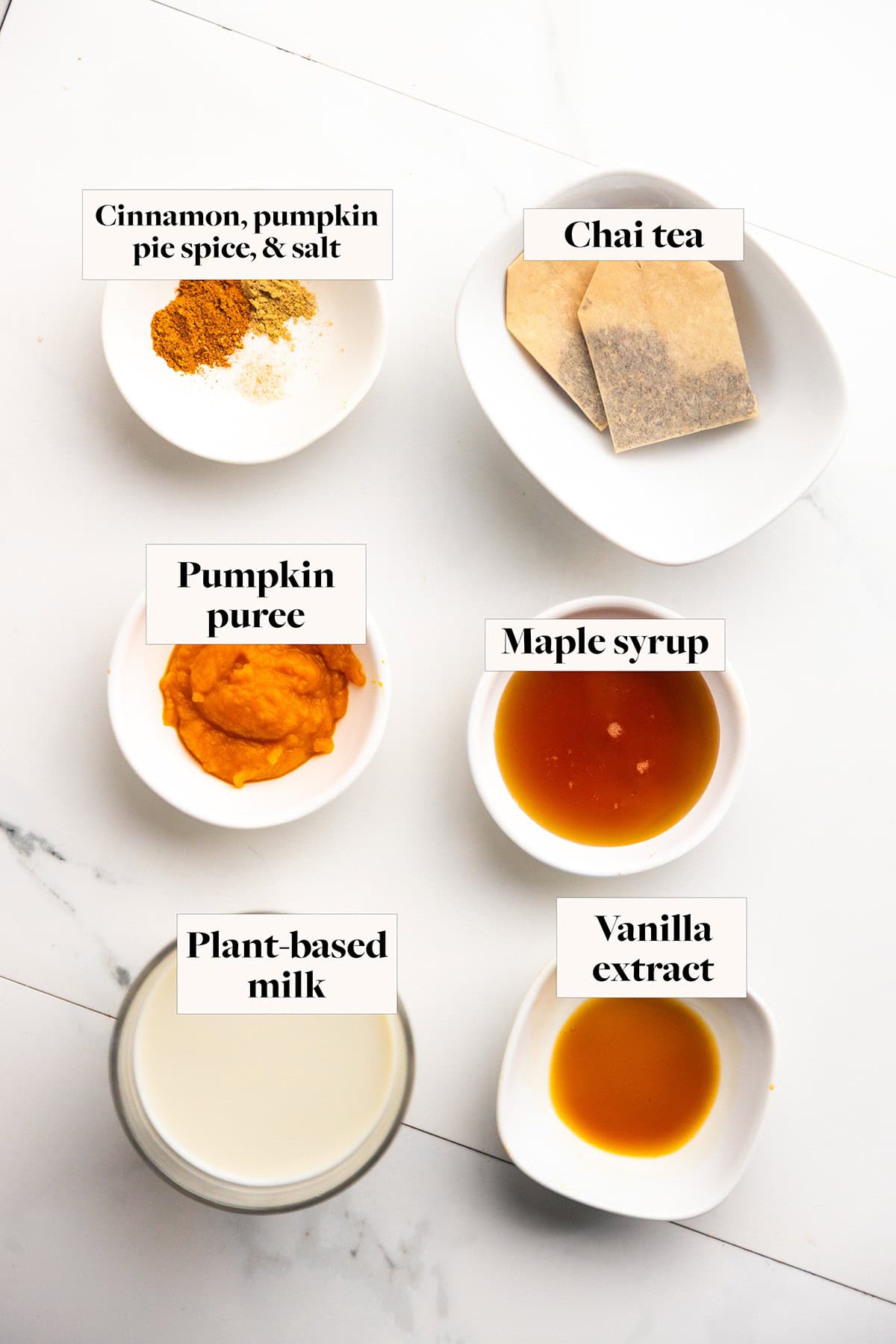Ingredients for a pumpkin chai latte in labeled bowls.