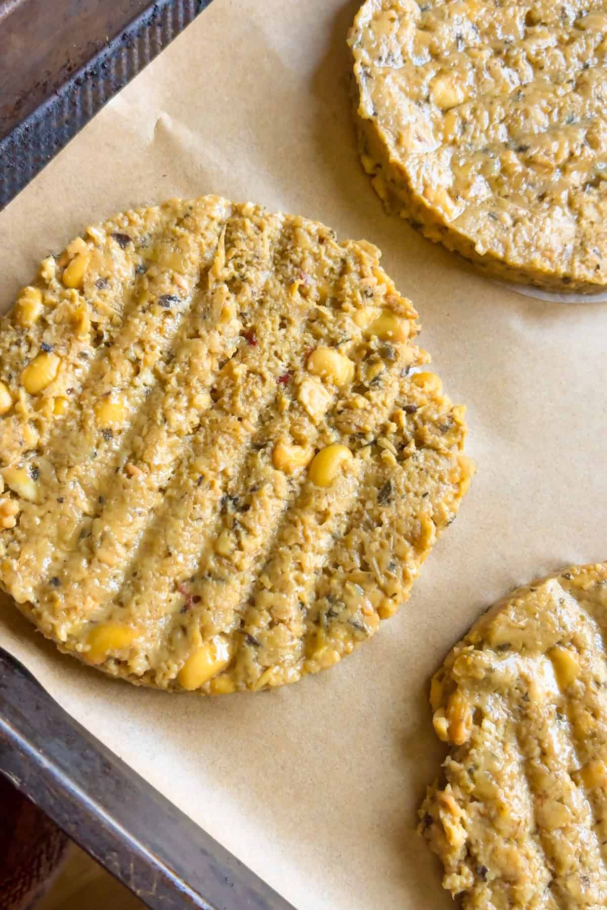 Soy burger patties on a baking sheet before baking.