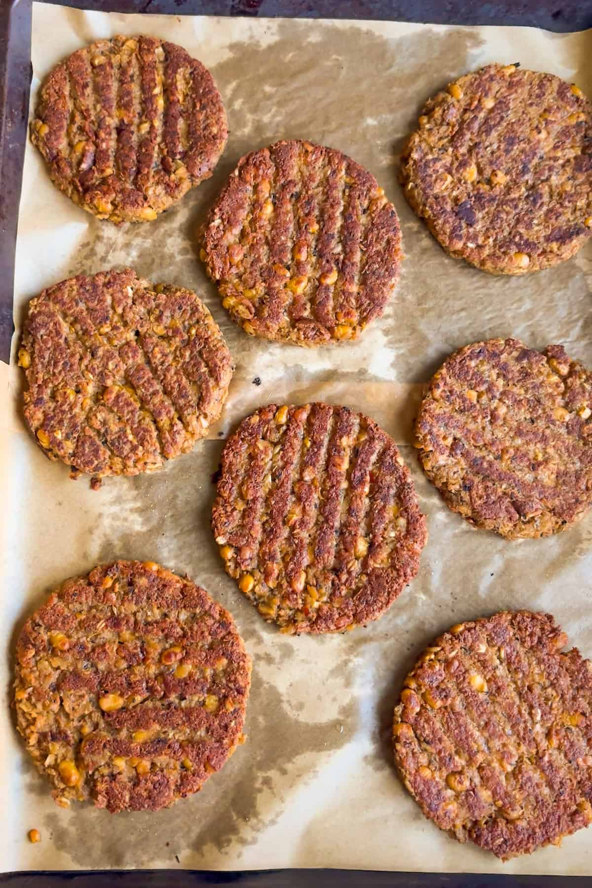 Baked soybean burgers on a baking sheet.