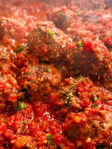 Impossible meatballs topped with fresh parsley simmering in marinara sauce.