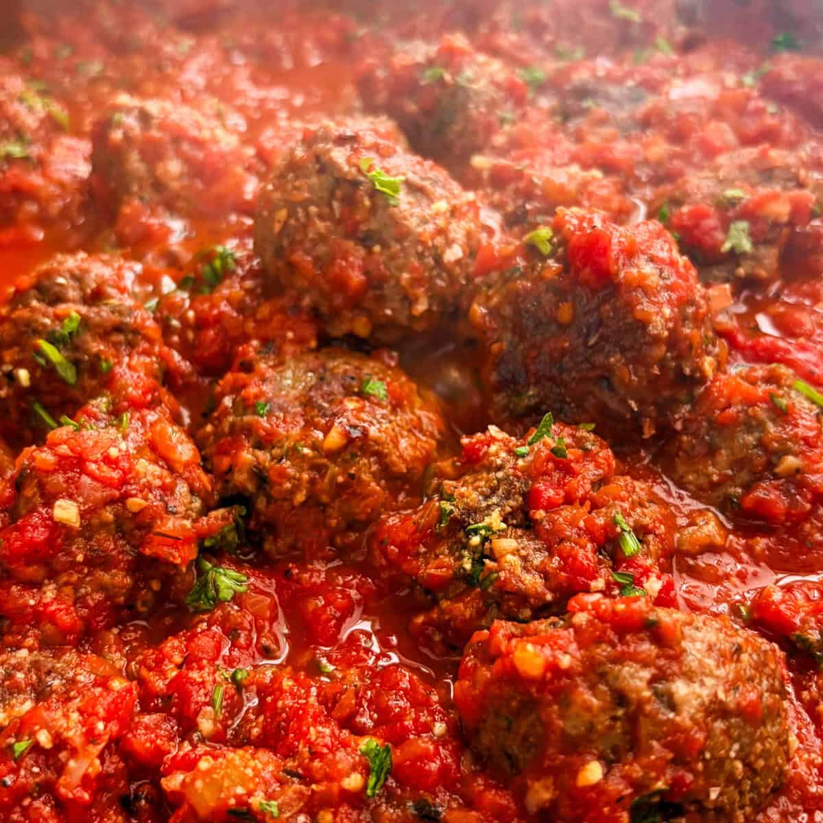 Impossible meatballs topped with fresh parsley simmering in marinara sauce.