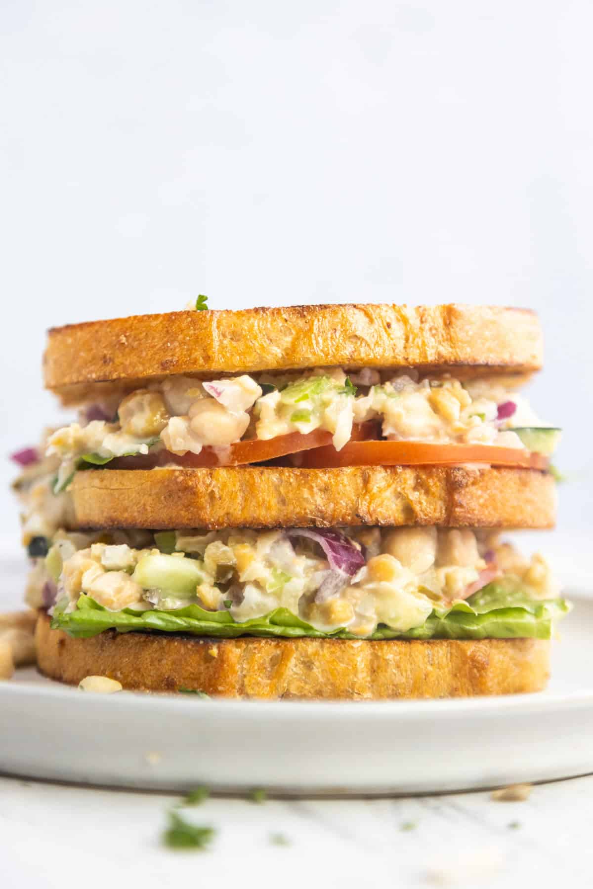 Chickpea salad sandwich on a a white plate.
