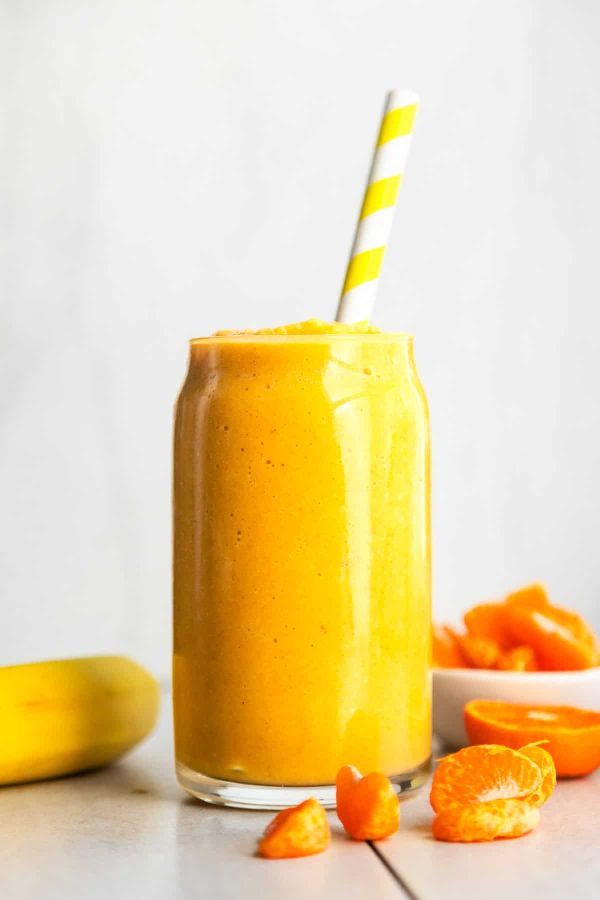 Dairy-free orange creamsicle smoothie in a glass with mandarin oranges slices on the side.
