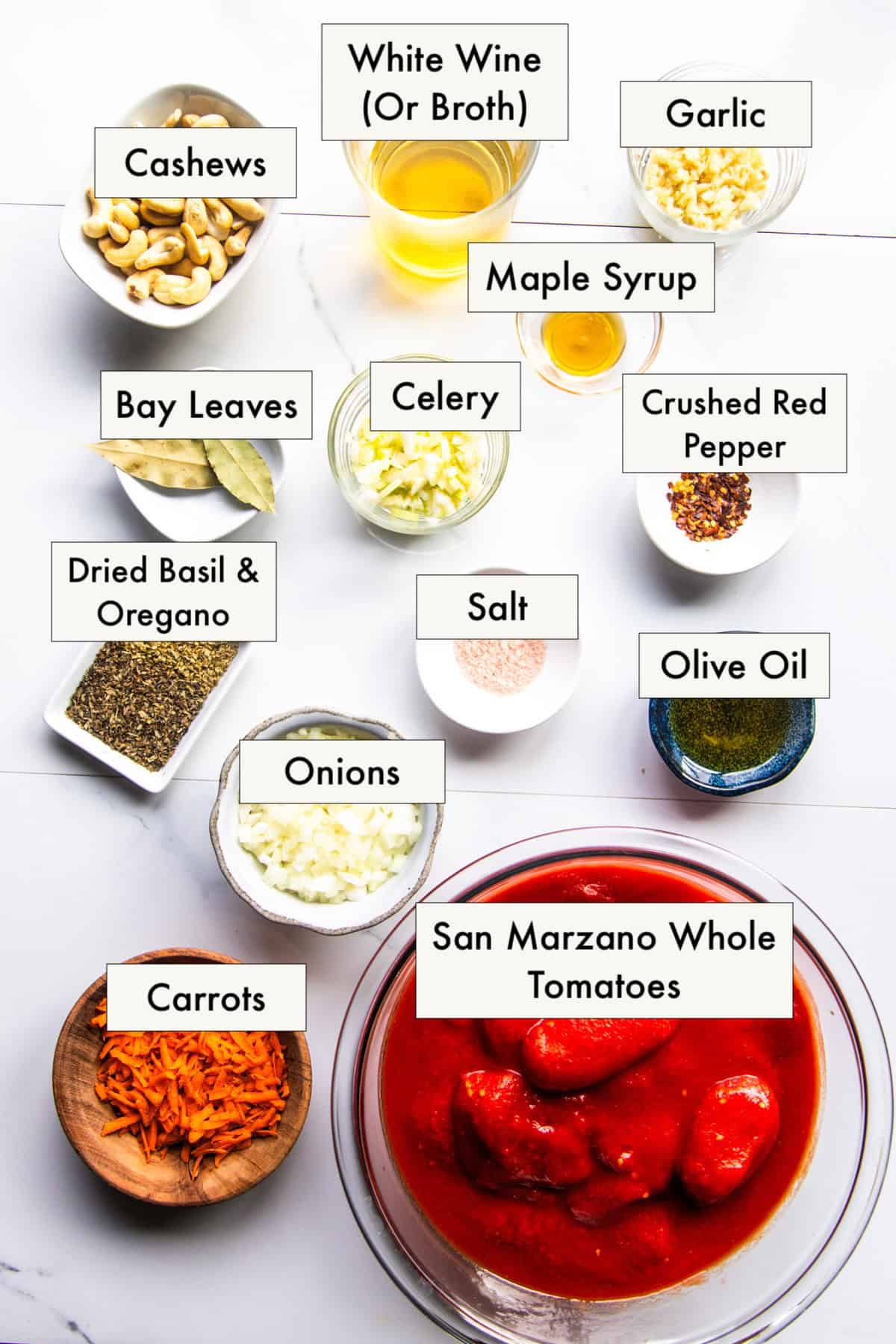 All ingredients needed to make vegan pink pasta (creamy tomato cashew sauce) arranged in labeled bowls.