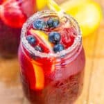 Blueberry lemonade in a mason jar topped with fresh blueberries.