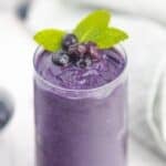 Dairy-free blueberry smoothie in a glass topped with mint.