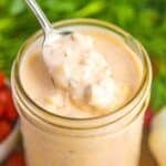 Vegan thousand island dressing in a jar with a spoon.