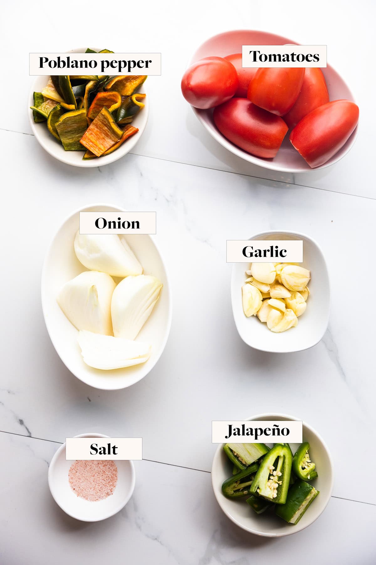 Labeled ingredients for red roasted salsa in small bowls.