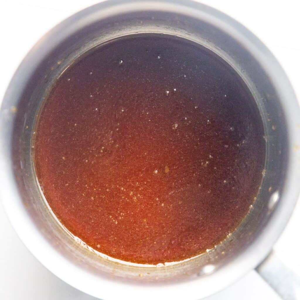 Sticky maple glaze sauce cooking in a pan.