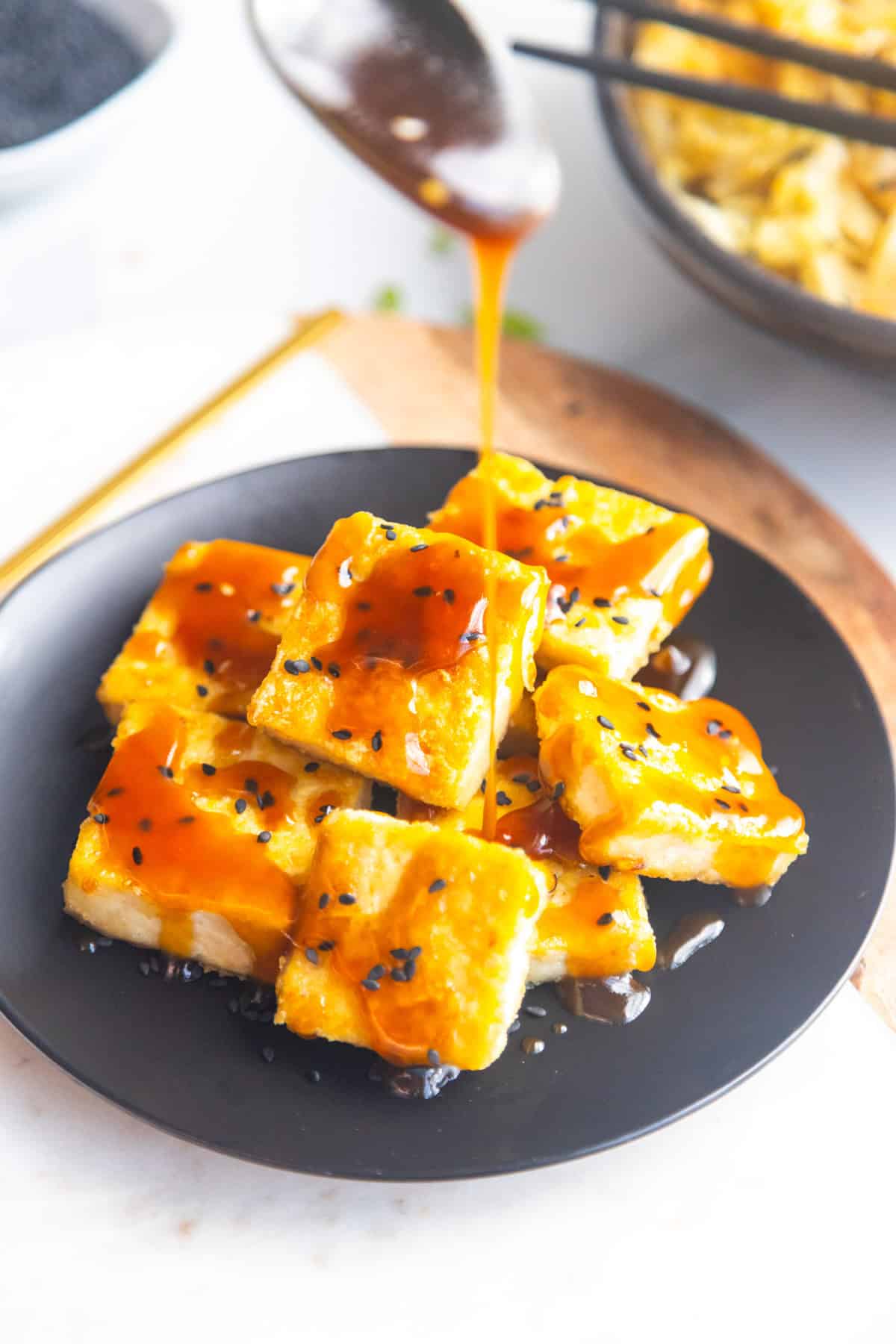 Sticky maple glaze sauce pouring over crispy tofu.