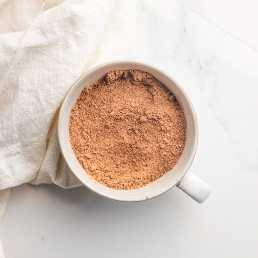 Dry ingredients for a vegan chocolate mug cake in a mug.