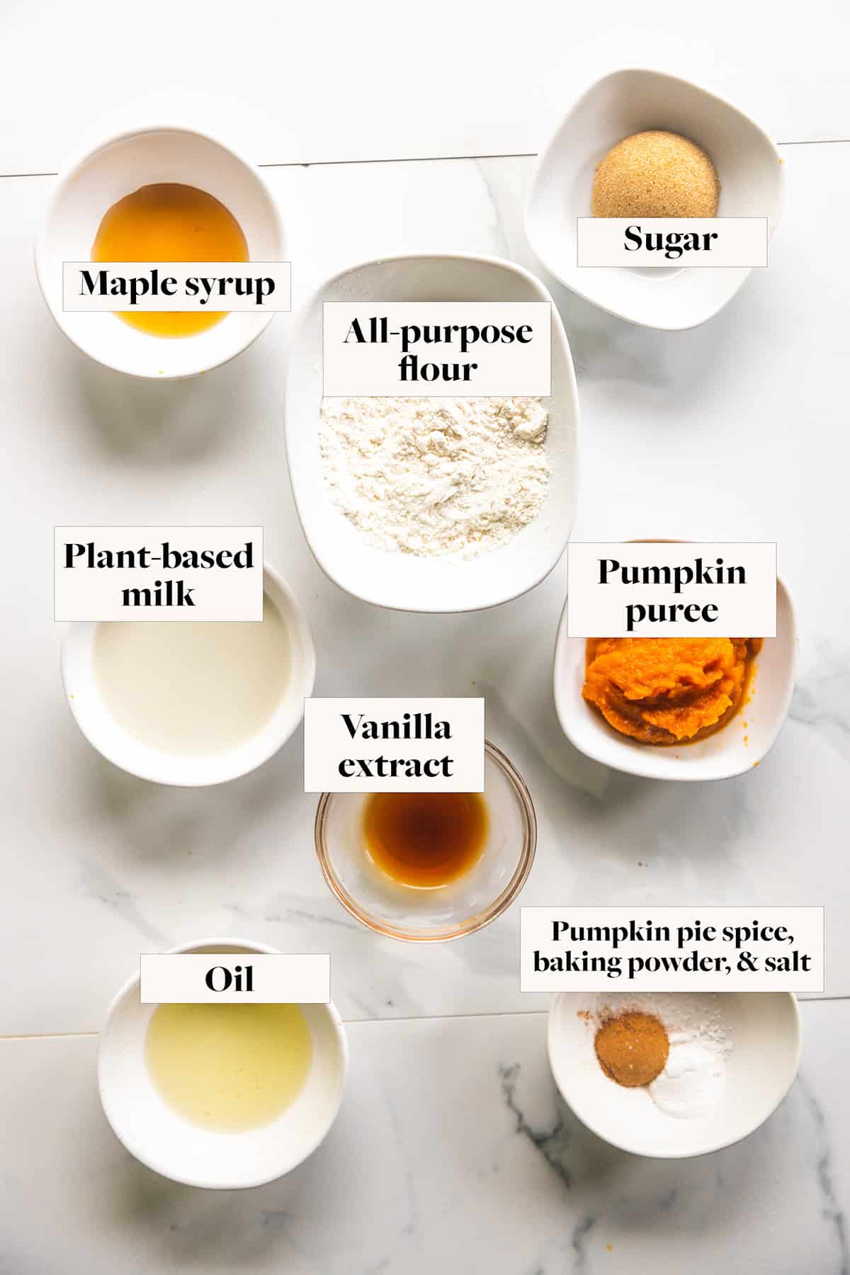 Ingredients for a vegan pumpkin mug cake in labeled bowls.