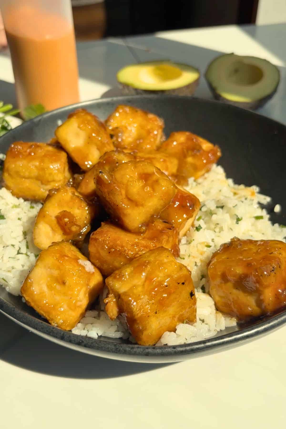 Cooked white rice and crispy tofu in a bowl.