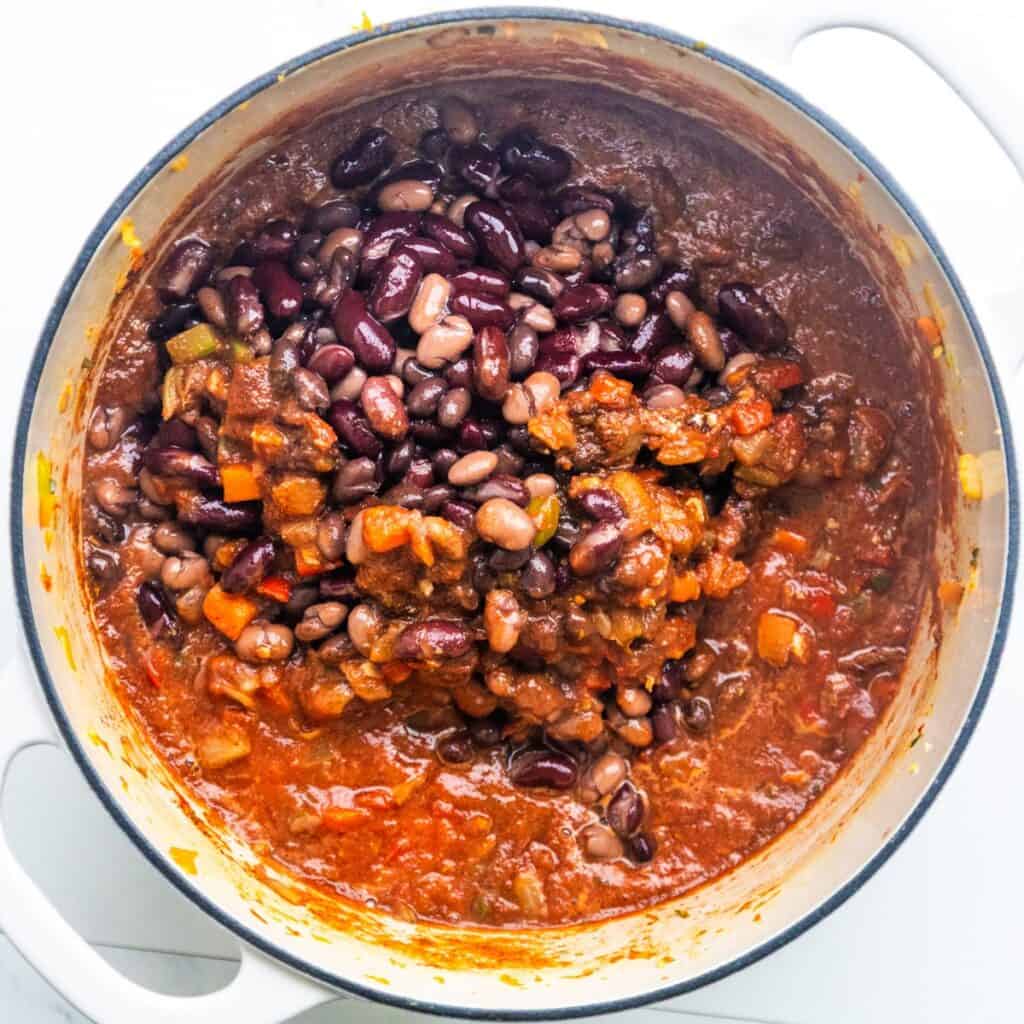 Ingredients being added to a dutch oven.