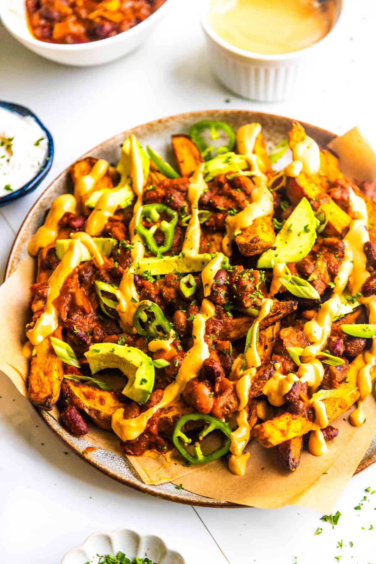 Vegan loaded chili sweet potato fries on a plate.