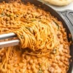 Vegan marry me chickpeas with pasta in a skillet with naan on the side.
