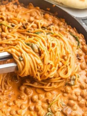 Vegan marry me chickpeas with pasta in a skillet with naan on the side.