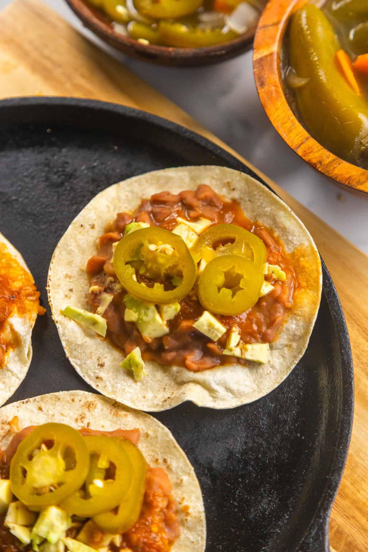 Pickled jalapeños carrots and onions served on a tortilla with beans and salsa.