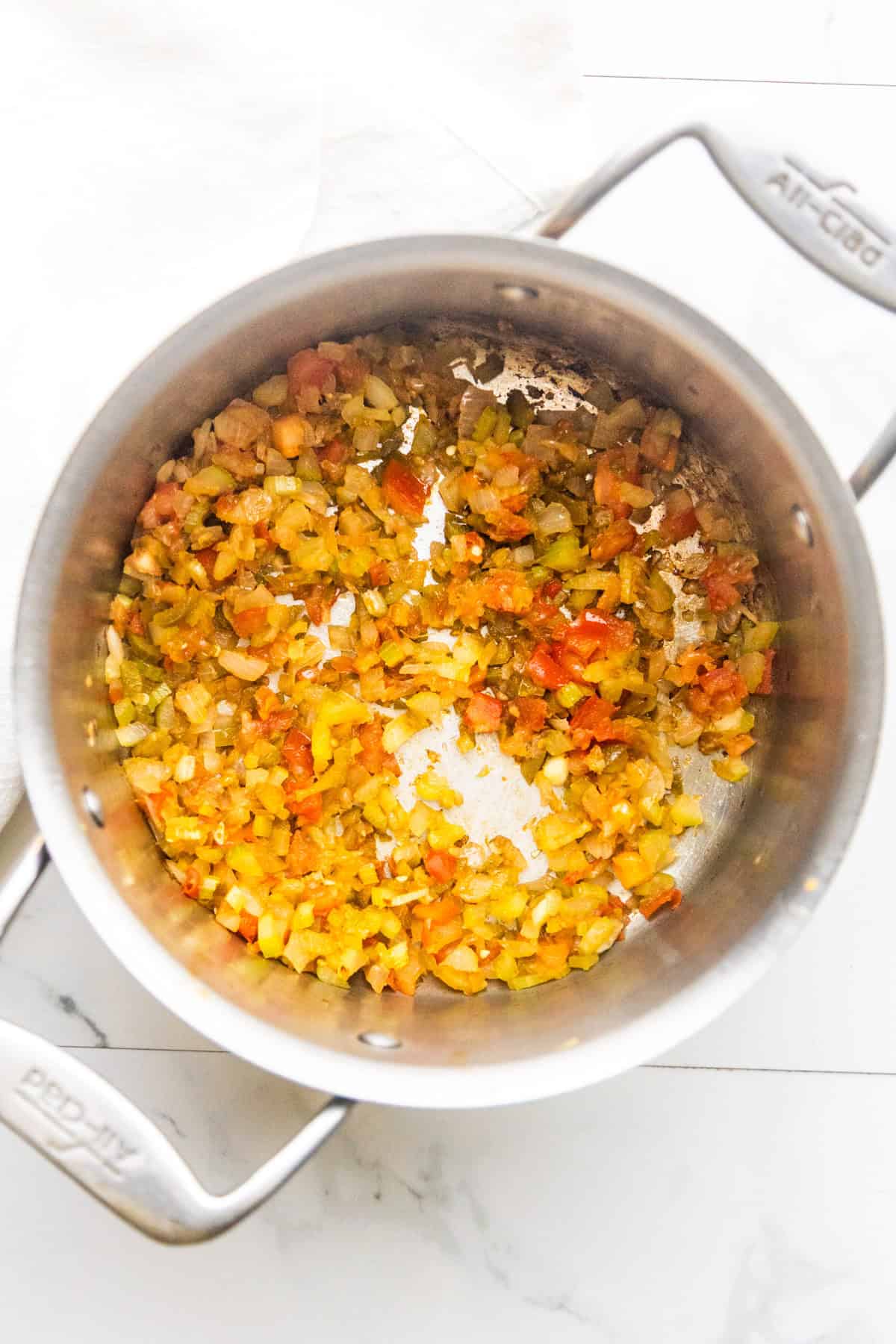 Onions, carrots, celery, & garlic sautéing in a pan.