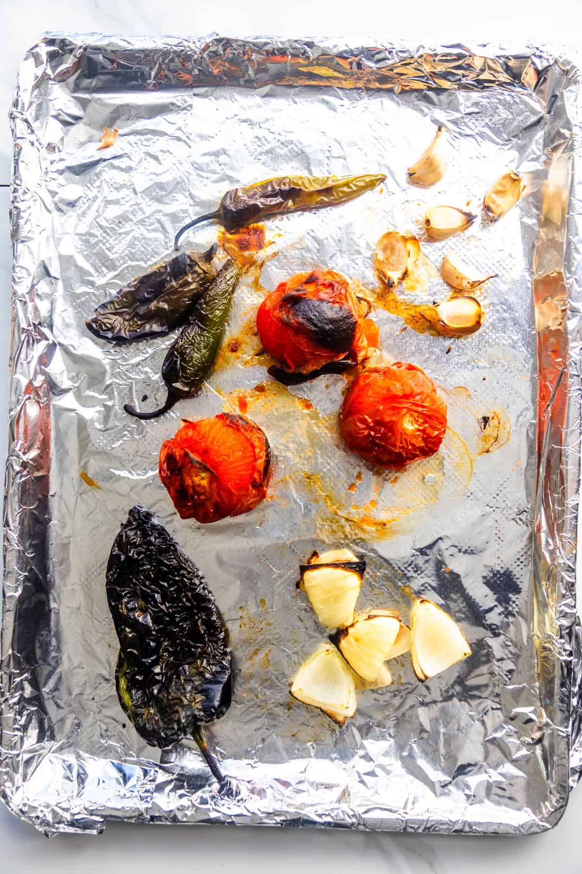 Roasted veggies on a baking sheet fitted with aluminum foil.