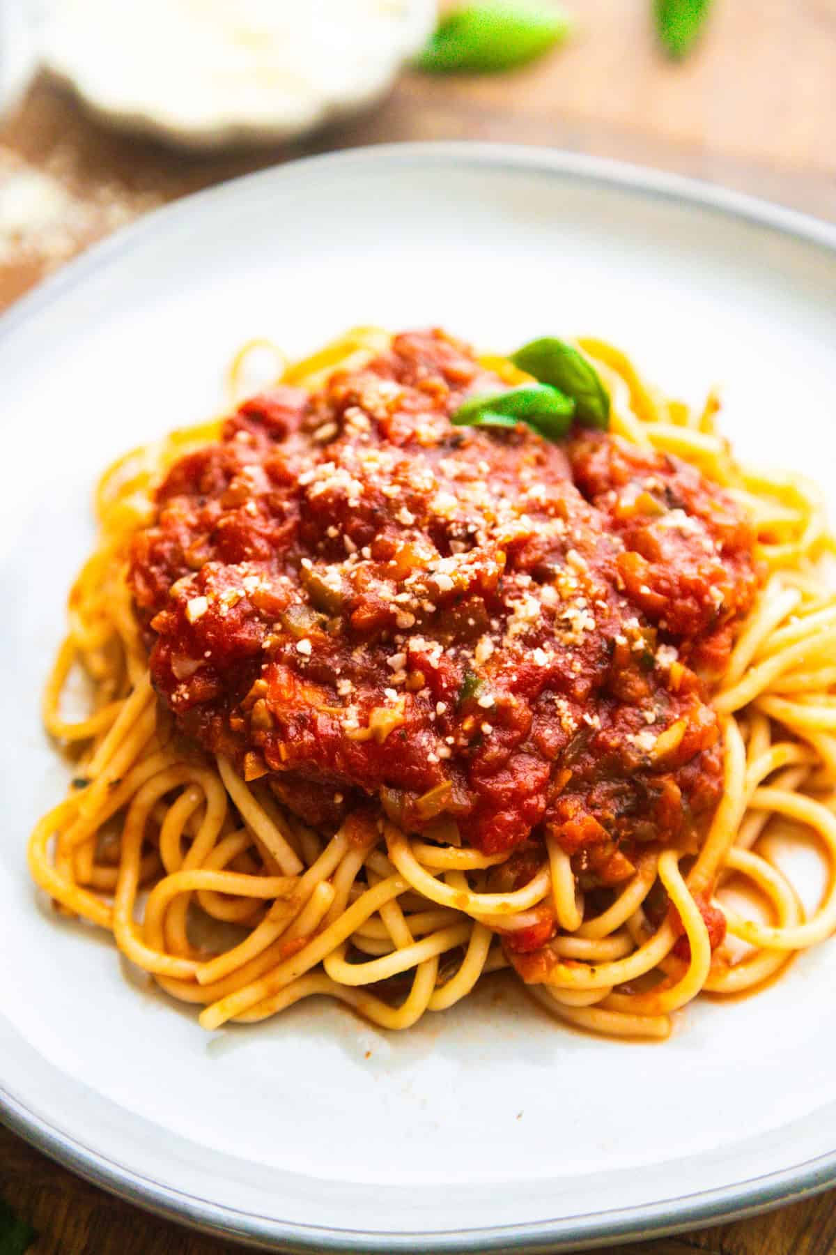 Veg loaded vegan spaghetti sauce served on pasta and topped with fresh basil.