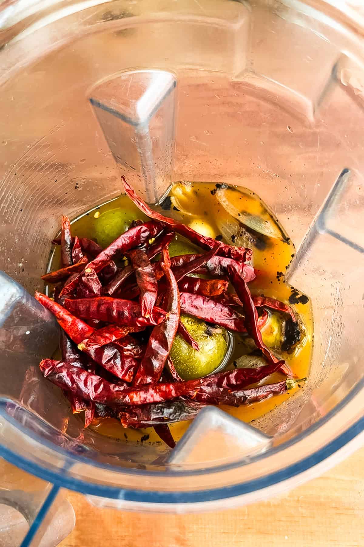 Charred veggies and chilis in a blender with water.
