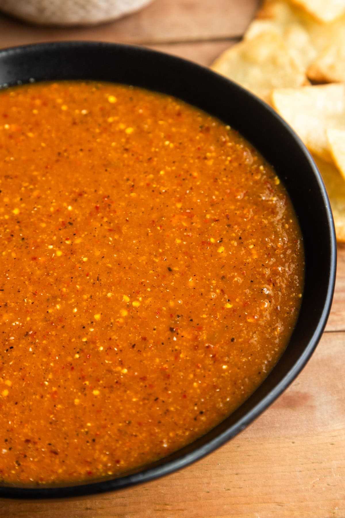 Toasted chile de árbol salsa in a bowl with chips on the side.