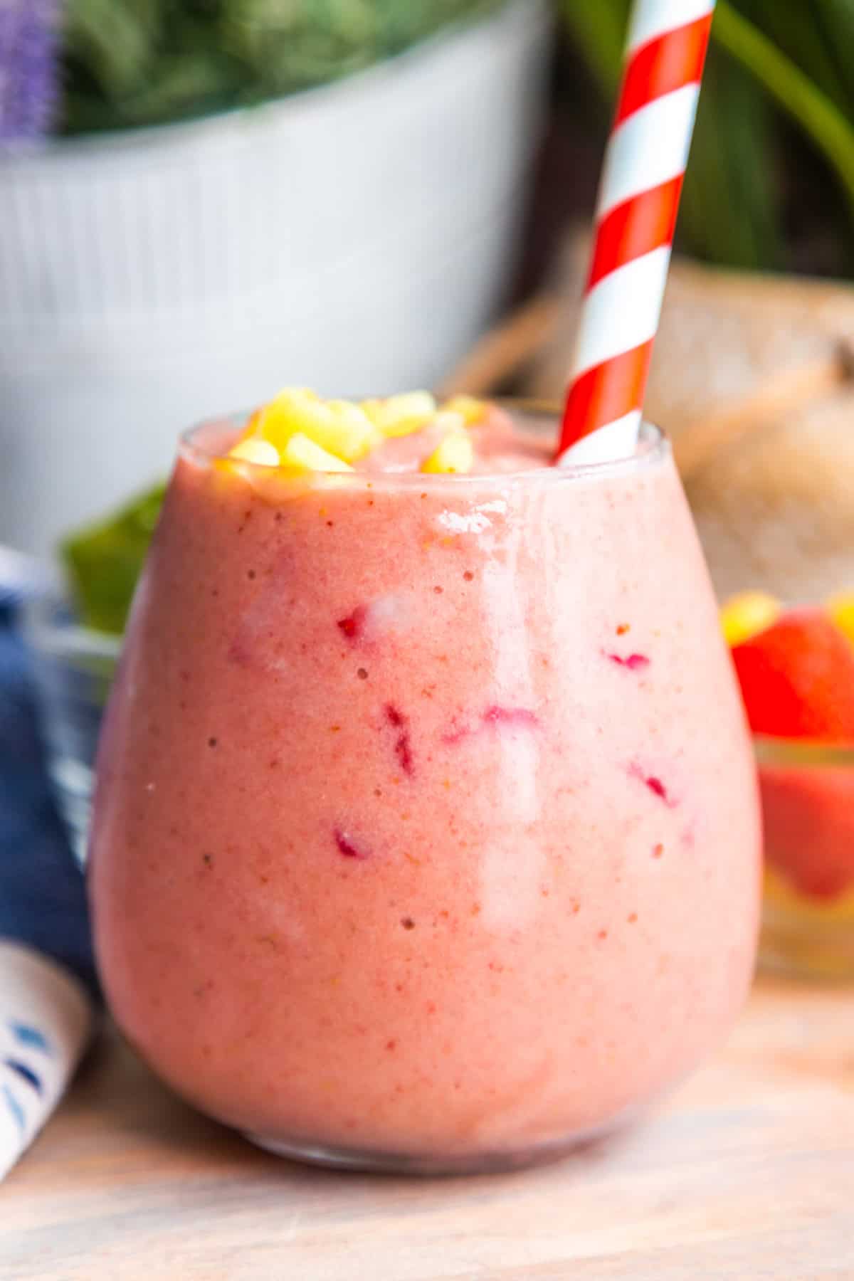 Cactus smoothie (licuado de nopales) in a glass with fresh fruit on the side.