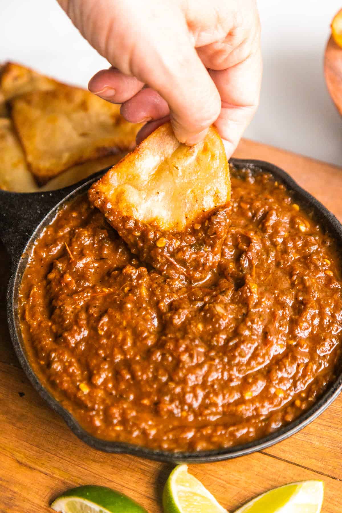 Salsa tatemada in a small cast iron pan with chips on the side.