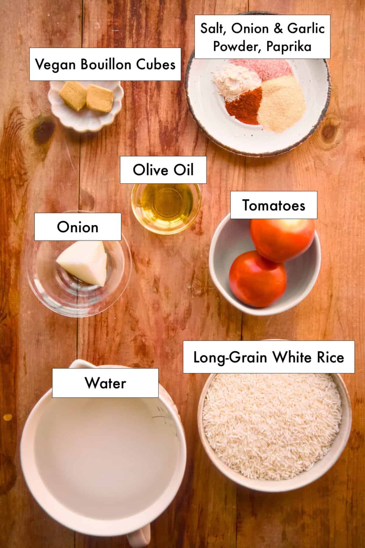 All ingredients for vegan Mexican rice with vegetables in labeled bowls laid out on a counter.