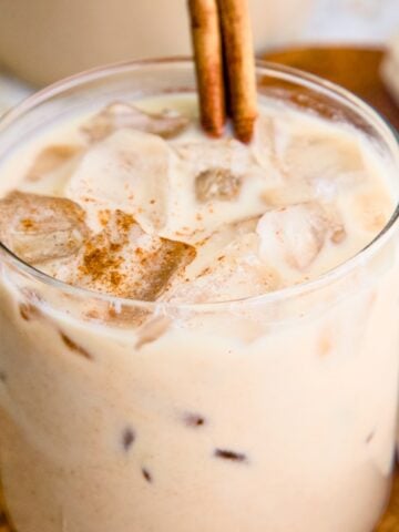 Vegan horchata (Mexican rice milk) in a glass topped with a cinnamon stick.