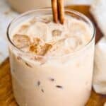 Vegan horchata (Mexican rice milk) in a large glass with ice and topped with a cinnamon stick.