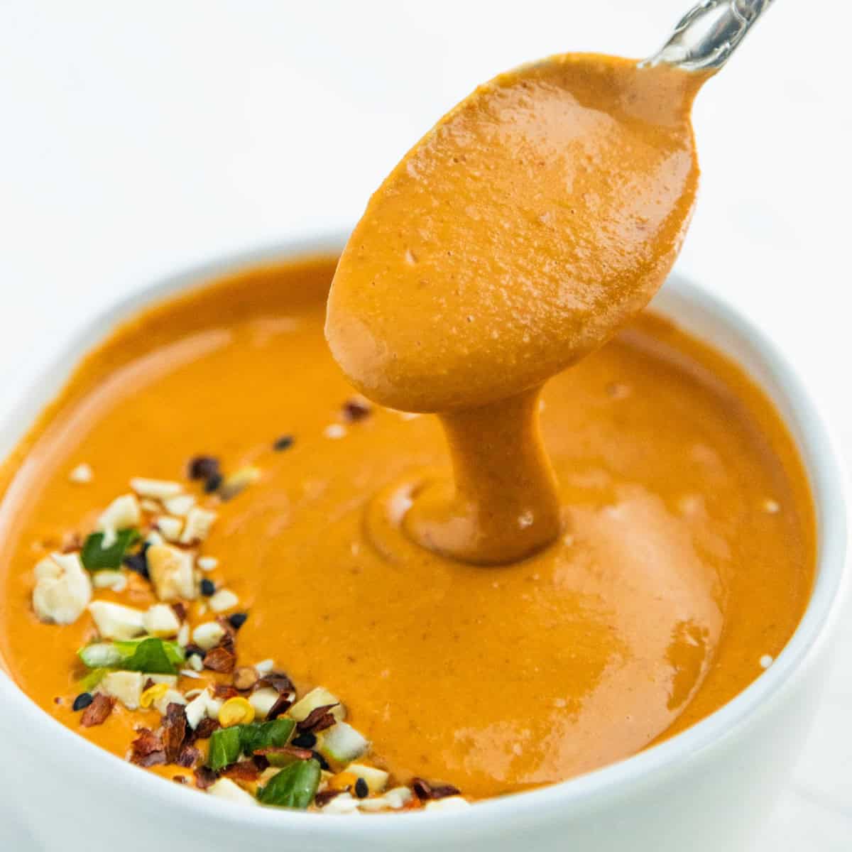 Asian peanut sauce in a bowl with a spoon.