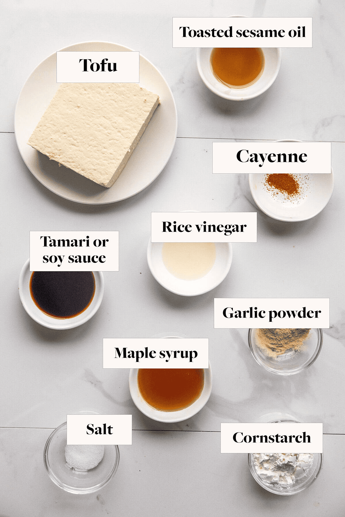 Ingredients for sticky tofu recipe (crispy maple glazed tofu) in bowls on a counter.