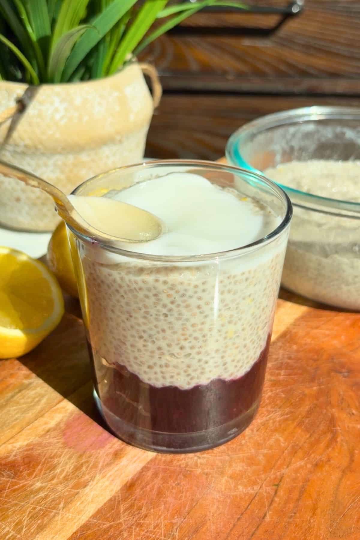 Lemon blueberry chia pudding layering in a glass with yogurt.