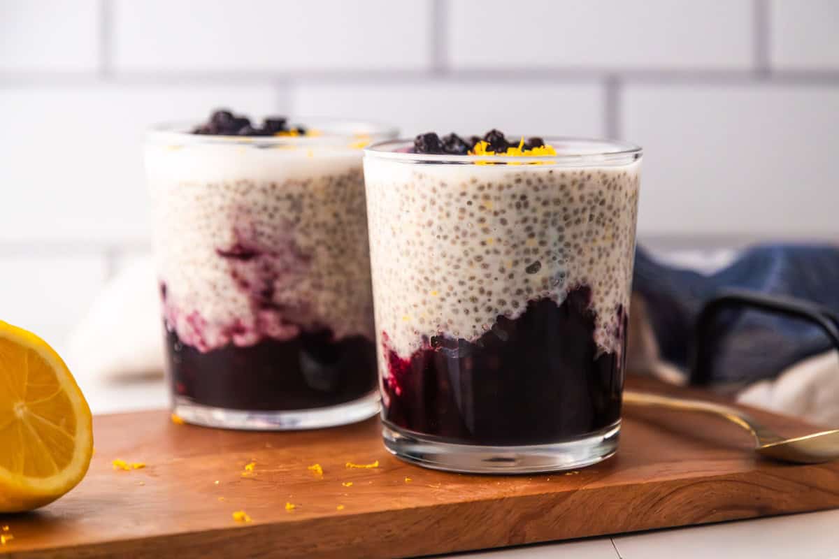 Lemon blueberry chia pudding on a counter in 2 glasses.