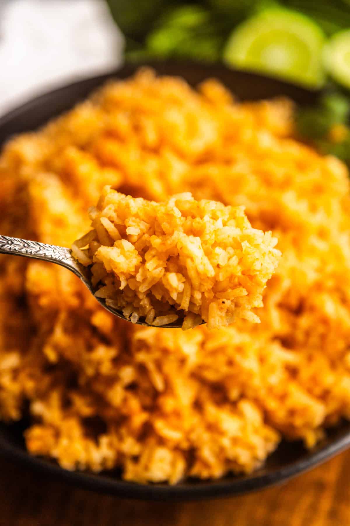 Spoon holding up Mexican rice for tacos (simple Mexican rice).
